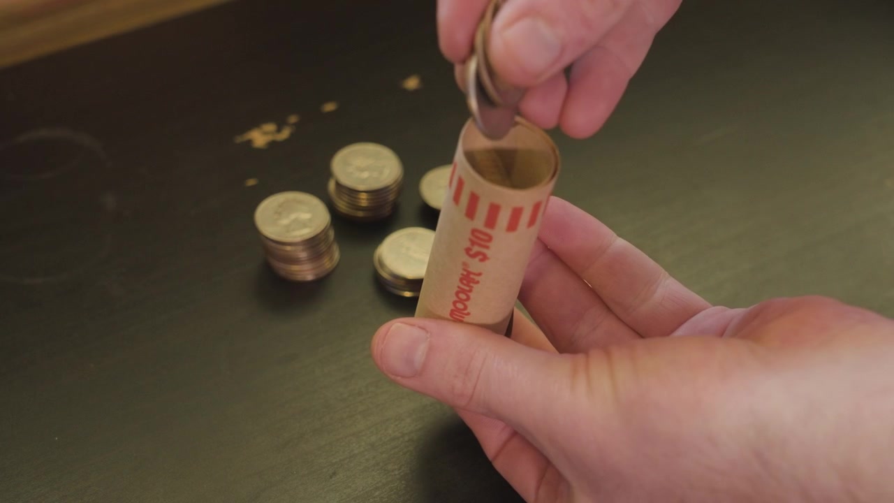 Quarti di dollaro americani che rotolano - Clip con variazione di velocità delle monete che cadono nel contenitore.