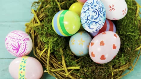 huevos de pascua pintados en el nido en una superficie de madera