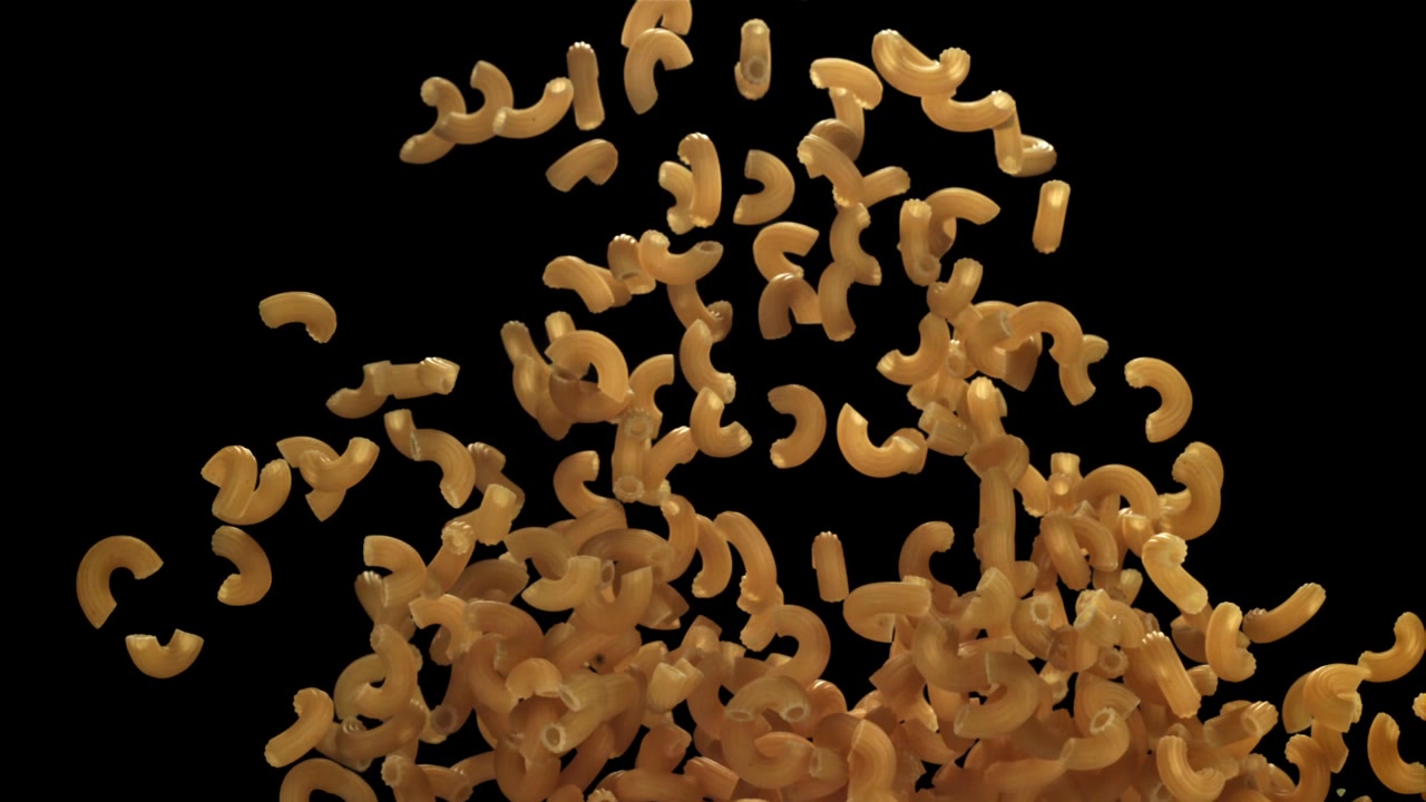 Dry Macaroni Pasta Falling in Slow Motion Against Black Background