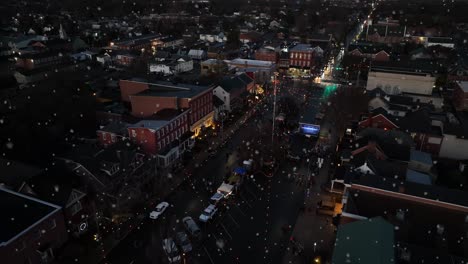 Der-Rückzug-Aus-Der-Luft-Enthüllt-Den-Stadtplatz-Während-Des-Winterschnees-In-Der-Nacht