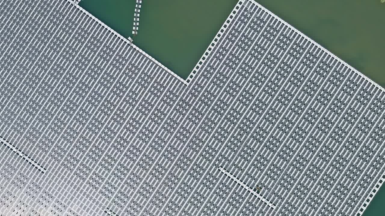 Solar farm panels in aerial view, array of polycrystalline photovoltaics in solar power plant floating on the water in lake