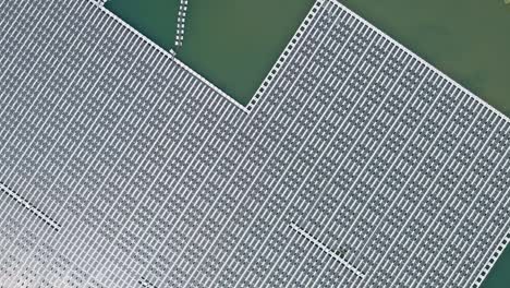 solar farm panels in aerial view, array of polycrystalline photovoltaics in solar power plant floating on the water in lake