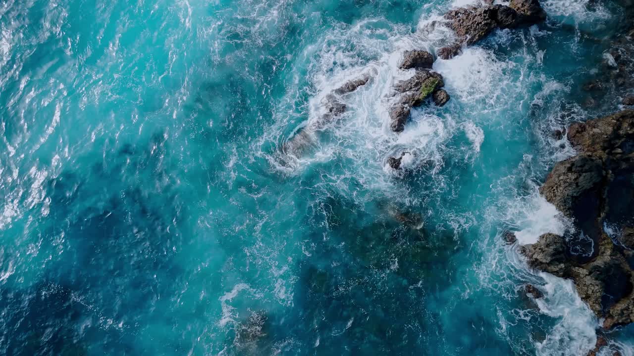Dramatic aerial drone footage of blue waves hitting the rocks in Los Hervideros in Lanzarote, Canary Islands, Spain.