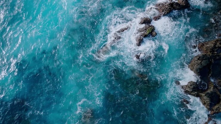 Dramatic aerial drone footage of blue waves hitting the rocks in Los Hervideros in Lanzarote, Canary Islands, Spain.