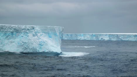 two huge tabular icebergs on a cloudy day