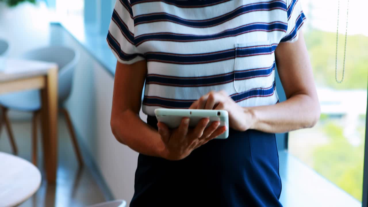 Woman tapping tablet in office causing alerts multiplying around torso, showing social media growth