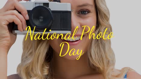 Animation-of-happy-caucasian-woman-holding-camera-over-national-photo-day-text