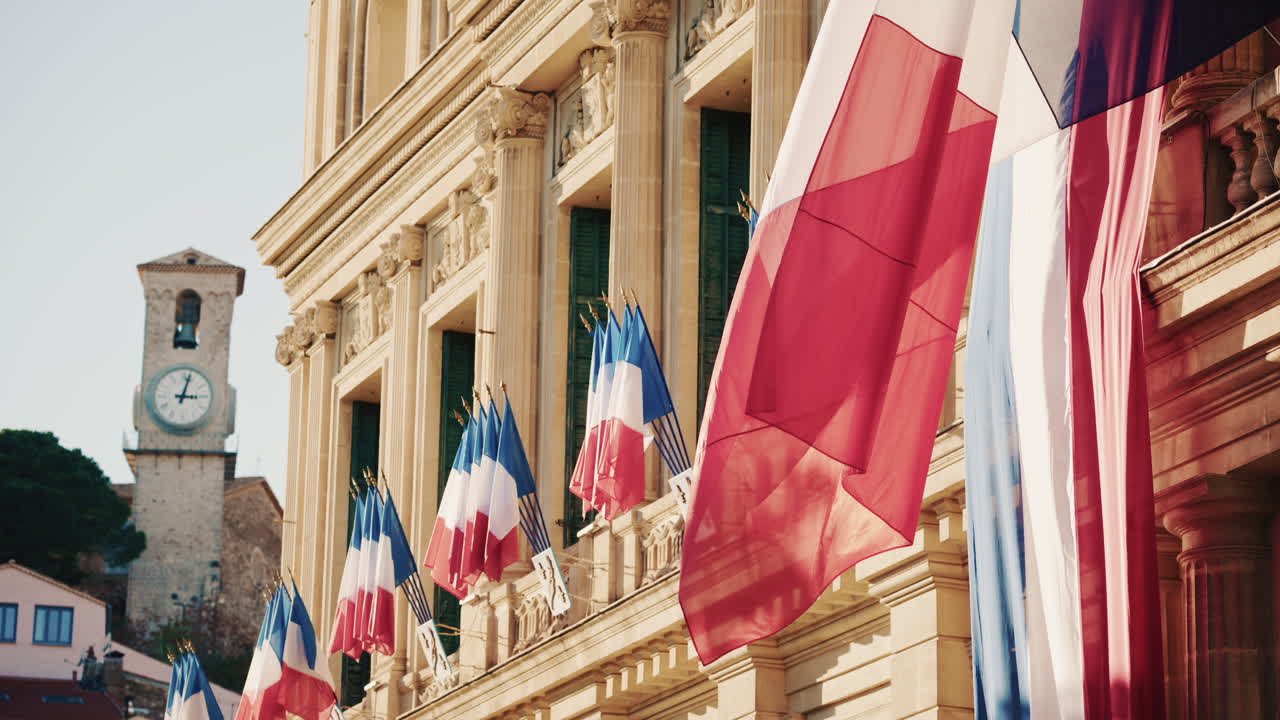 Campo lungo di un edificio storico decorato con bandiere tricolori francesi in una giornata limpida