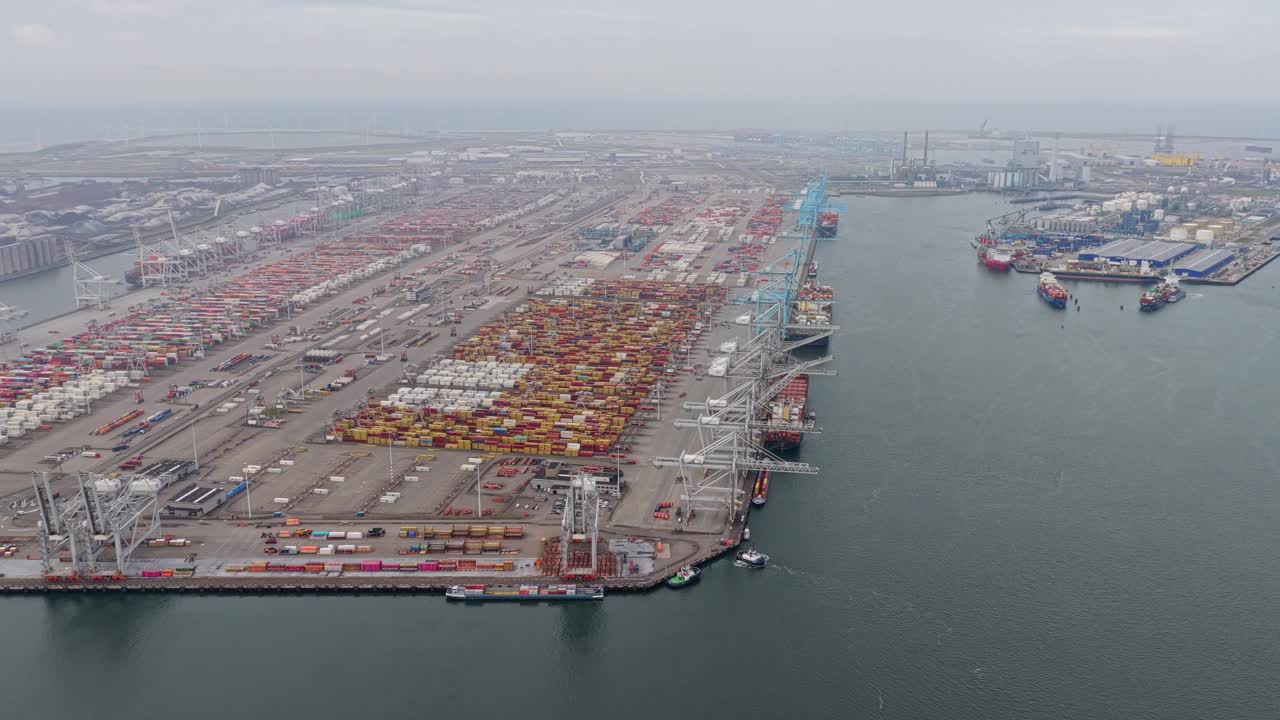 Drone view of Rotterdam freight harbor, container ships unloading goods