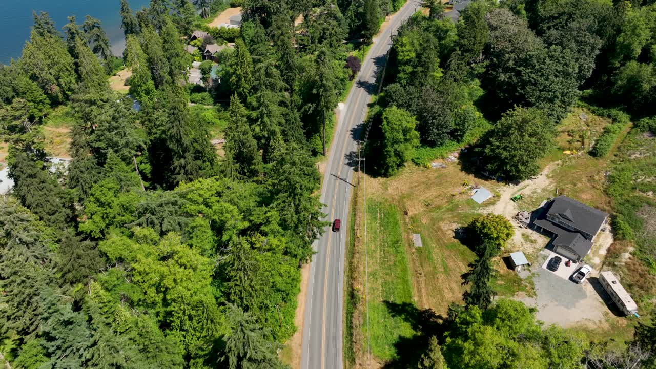 바다 근처를 운전하는 빨간 자동차의 오버헤드 드론 뷰