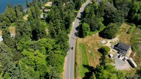 vista aérea de drones de un auto rojo conduciendo cerca del océano