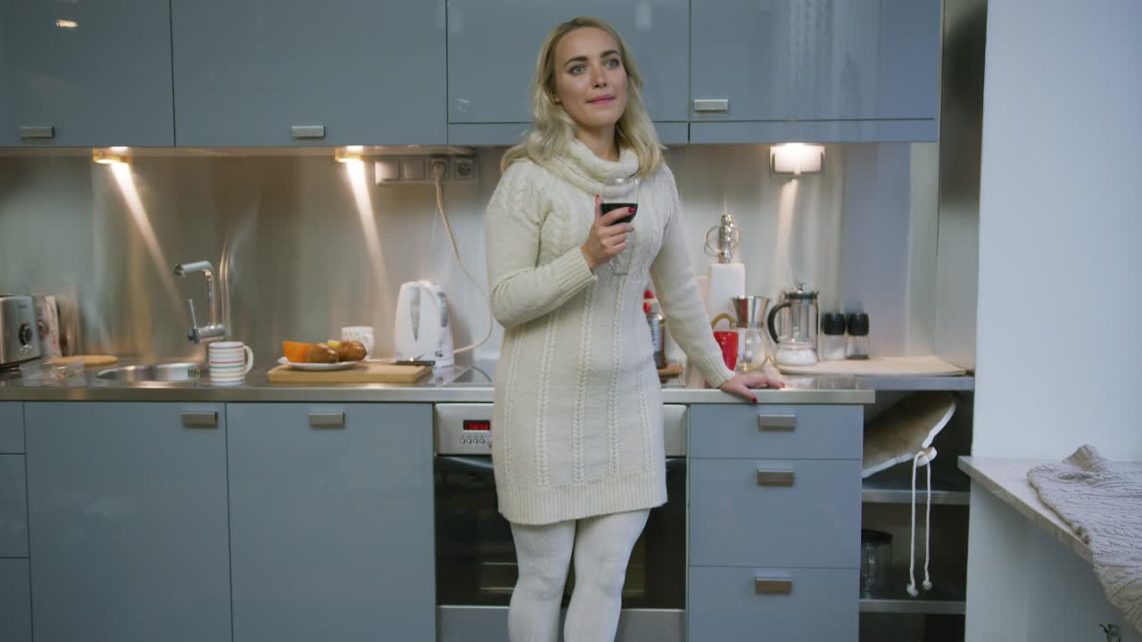 женщина с вином стоит на кухне