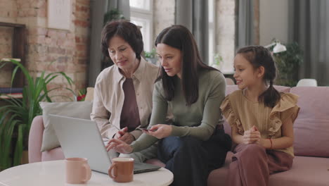 three generations of women using a laptop for online shopping