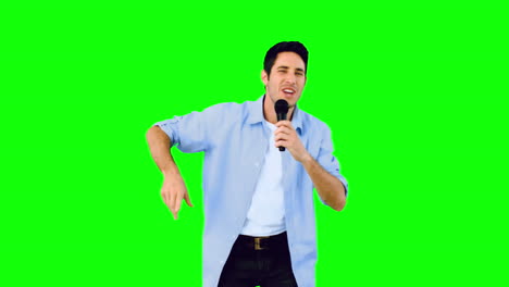 Man-singing-into-microphone-and-dancing-on-green-screen