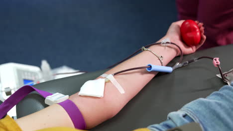 blood runs by the tube of a catheter attached to the arm of a woman. transfusion and donation of blood. close up.