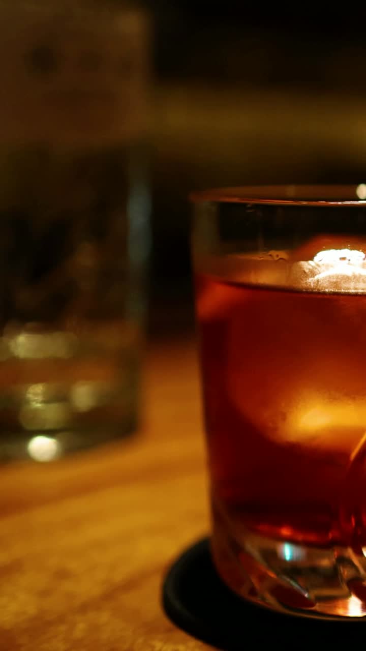 mano tomando un cóctel de un bar débilmente iluminado