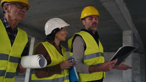 ingenieros caucásicos ocupados caminando por el sitio de construcción.