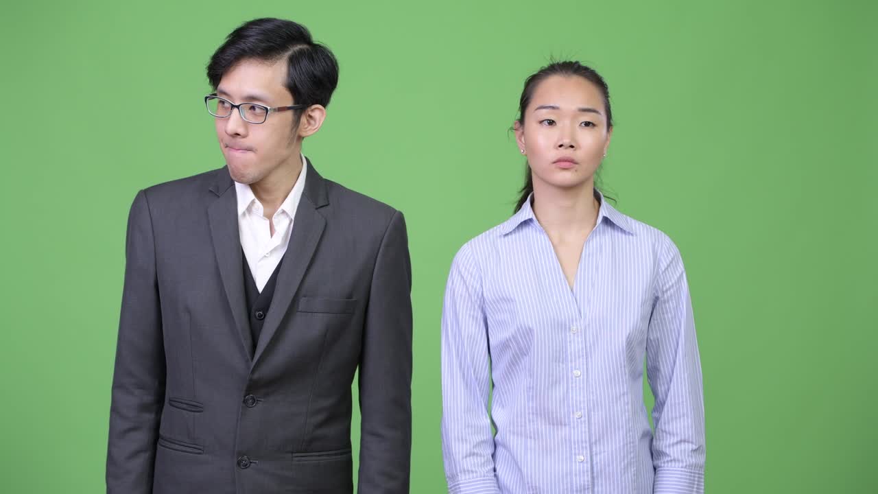 Young Asian business couple looking bored together