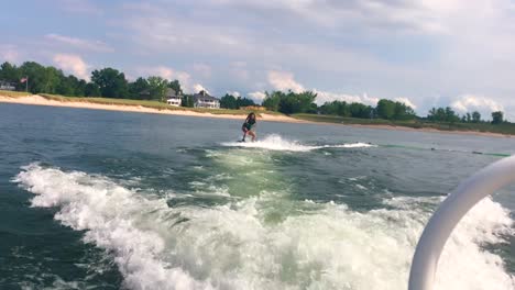 slow mo of girl wakeboarding on a summer day at the lake