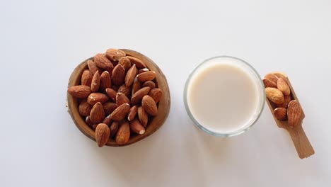 leche de almendra y almendras en un cuenco y en una cuchara