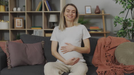 pregnant woman smiling on sofa