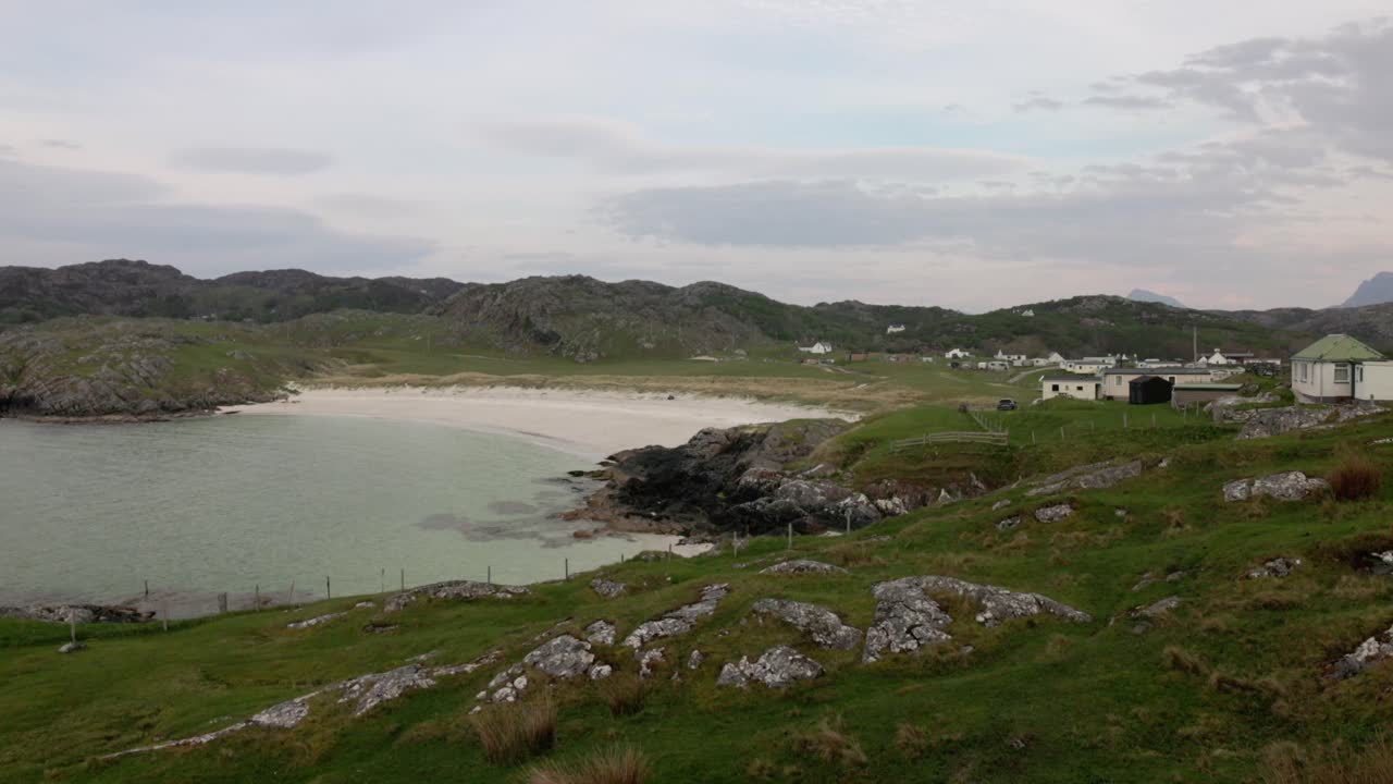 slow revealing shot of the landscape surrounding Achmelvich Beach in summer