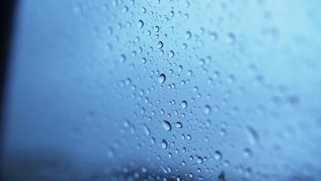 detailed shot of waterdrops sticking on outside of glass window of car