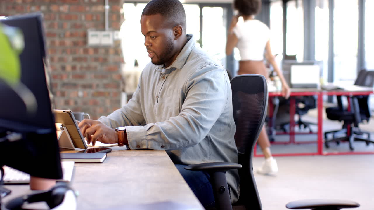 African american man working on laptop in modern office