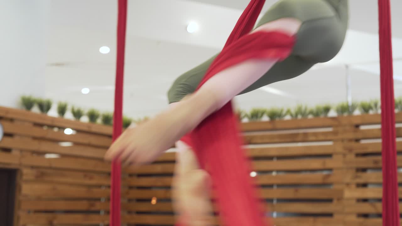 타이트한 레깅스와 플라이 요가 피트니스를 연습하는 핑크 탑을 입은 아름다운 소녀