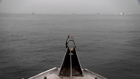 Ein-Boot-Fährt-Durch-Das-Wasser-Mit-Einem-Schwimmer-Und-Anderen-Booten-In-Der-Ferne