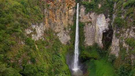 cinematic aerial view flying closer to the majestic sipiso piso waterfall in north sumatra, indonesia