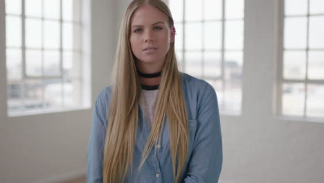 slow-motion-portrait-of-beautiful-young-blonde-woman-arms-crossed-looking-serious-pensive-at-camera-running-hand-through-hair-apartment-windows-background