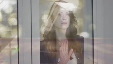 animation of light spots over caucasian woman looking through window