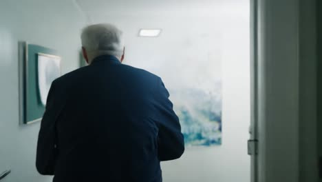 a man walks down a hallway in a business office.