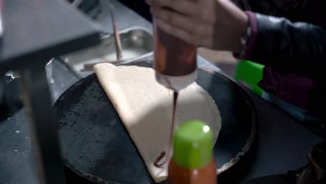 agregando crema de chocolate a la crepe