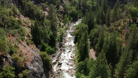 aerial descending shot of a fast flowing whitewater mountain river