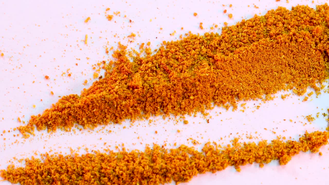 약간의 카레 향신료를 복용하는 숟가락의 매크로 샷