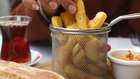 patatas fritas crujientes en una canasta con té y pan