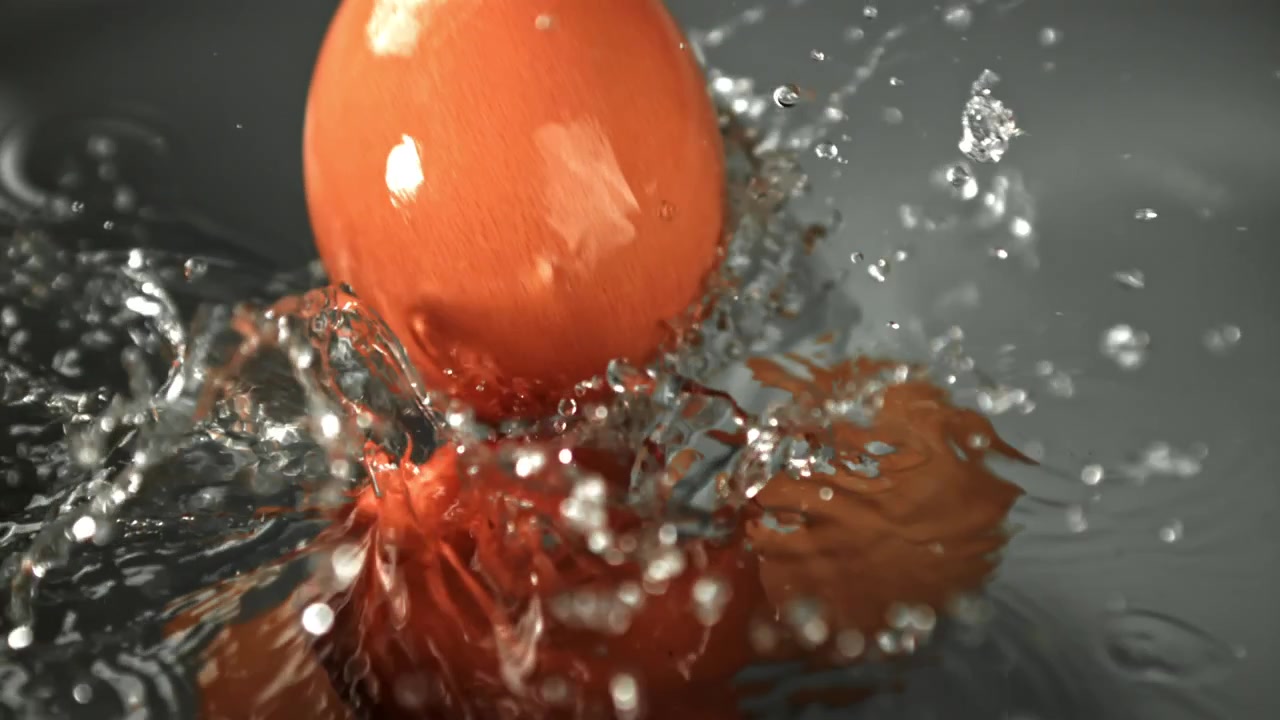 Uova fresche marroni che schizzano nell'acqua al rallentatore.