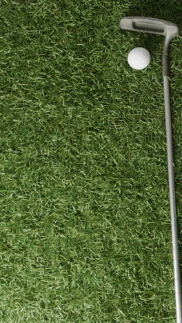 vertical viedo of golf ball and club on grass, copy space, slow motion