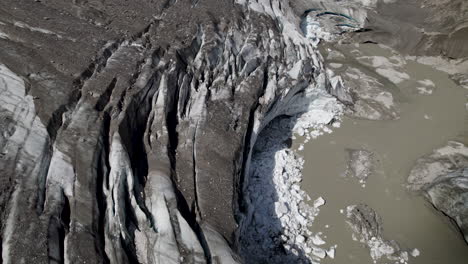 escombros cubiertos glaciar pasterze derretimiento cueva de hielo debido al cambio climático, retiro glaciar de los alpes orientales, austria, primer plano aéreo