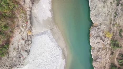 birdseye view looking down over a human standing on a bridge with beautiful tree fall colours in the autumn season