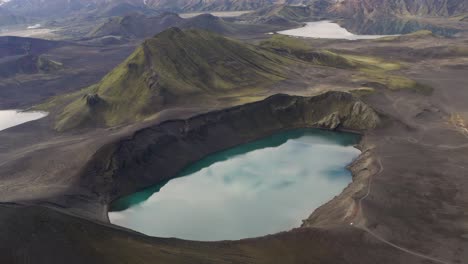 el cielo se refleja en las aguas del lago blahylur, un lago de cráter en las tierras altas del sur de islandia