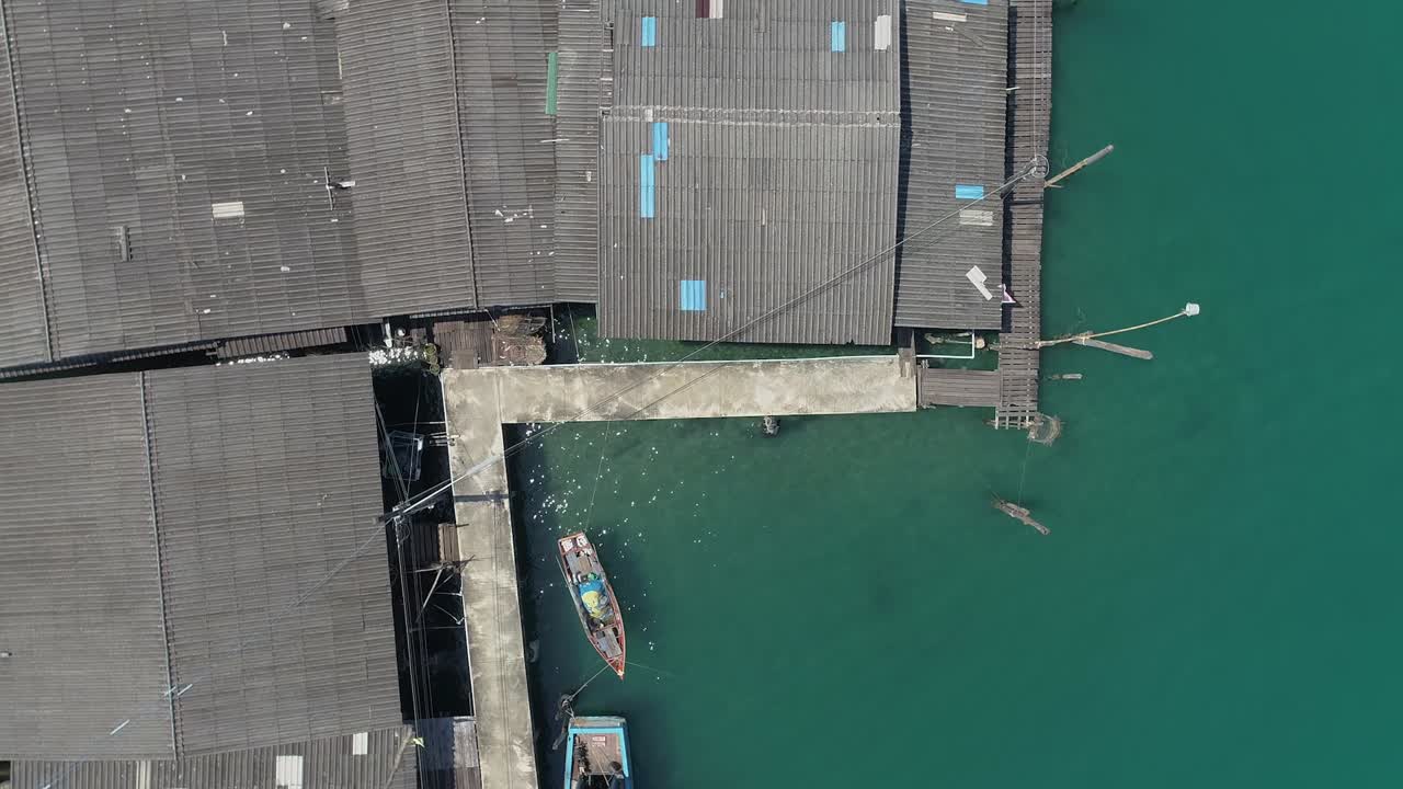 vista aérea de casas y un barco en un muelle sobre el agua turquesa