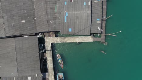 aerial view of houses and a boat on a pier over the turquoise water