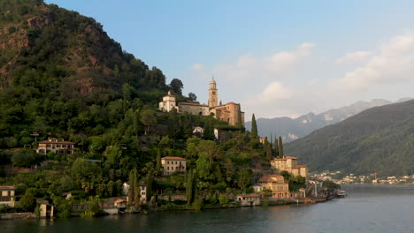 rotating drone shot of chiesa di santa maria del sasso in switzerland flying over lugano lake