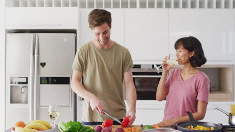 video de una pareja feliz y diversa preparando una comida juntos
