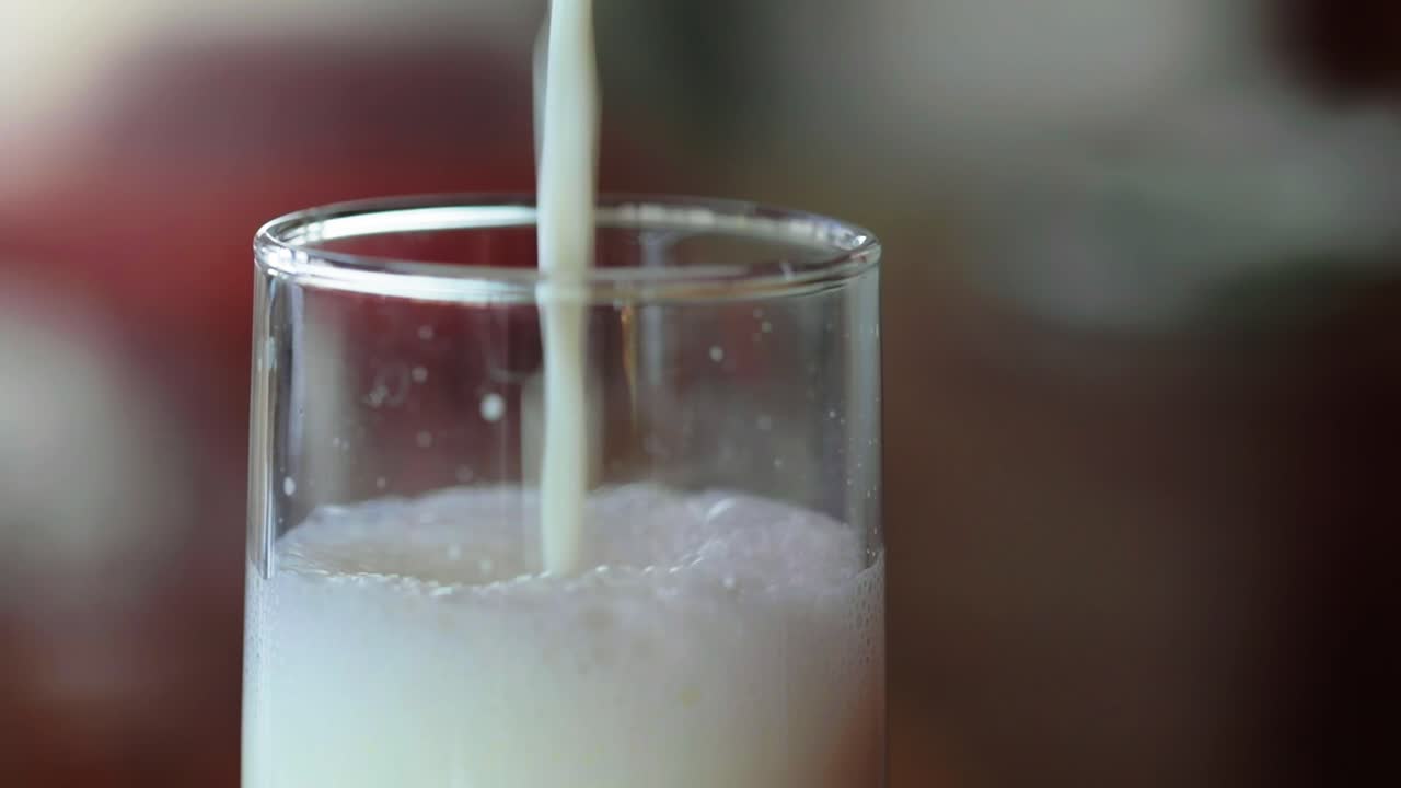 la leche se vierte en un vaso, toma de primer plano