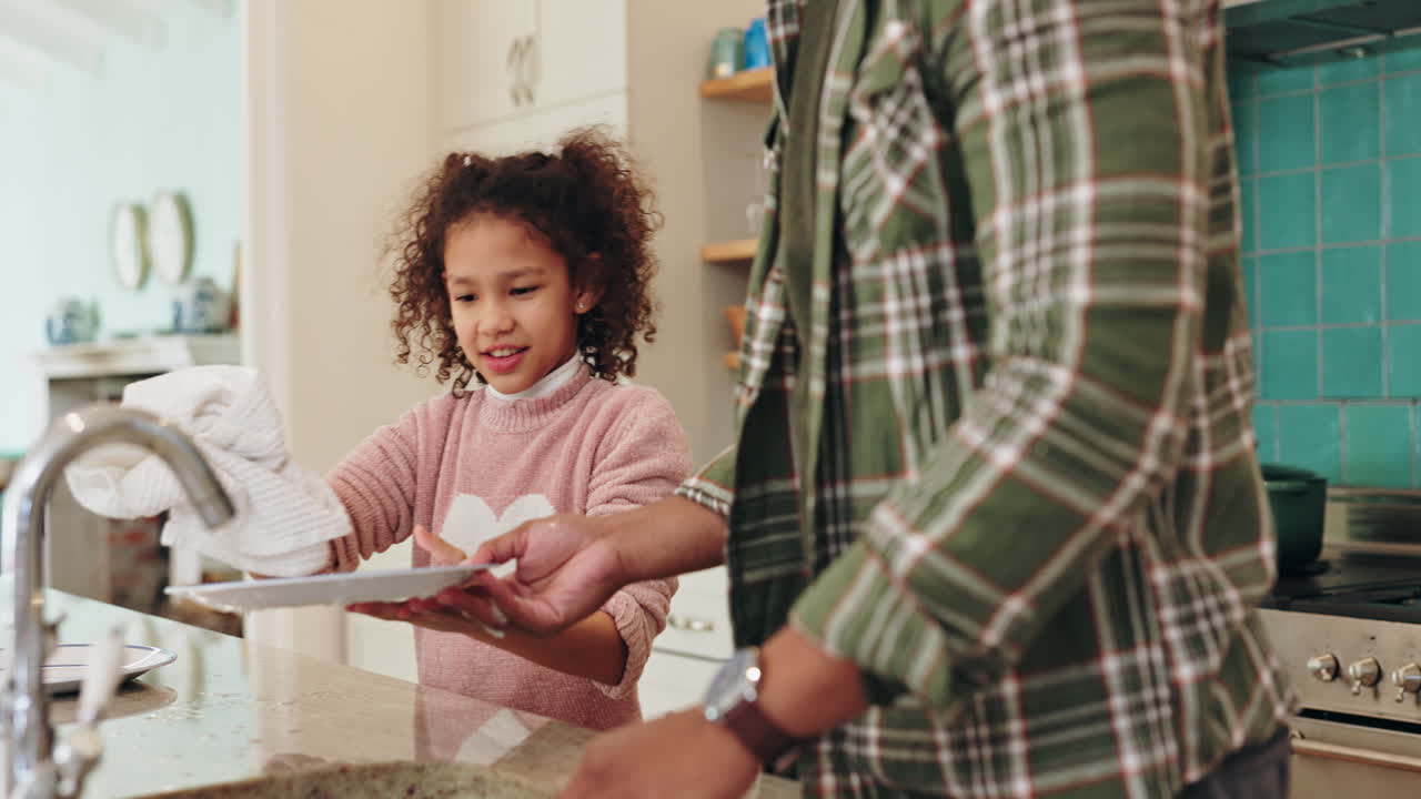 Father and Daughter Washing Dishes in Kitchen