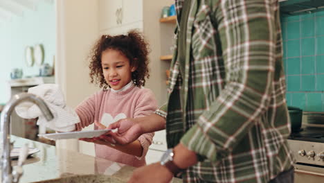 father and daughter washing dishes in kitchen